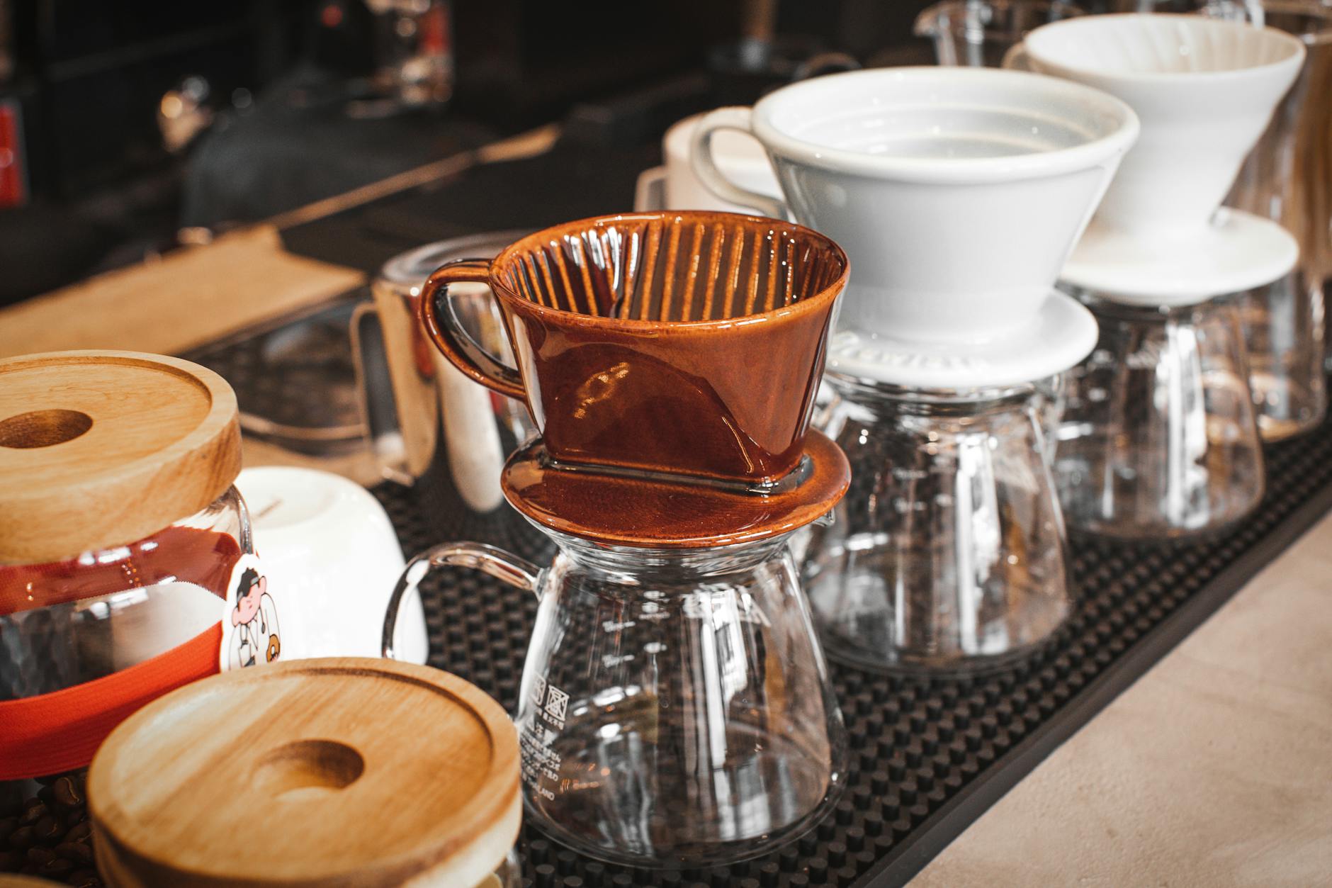 Ceramiczne i szklane drippery do kawy na ladzie w przytulnej kawiarni