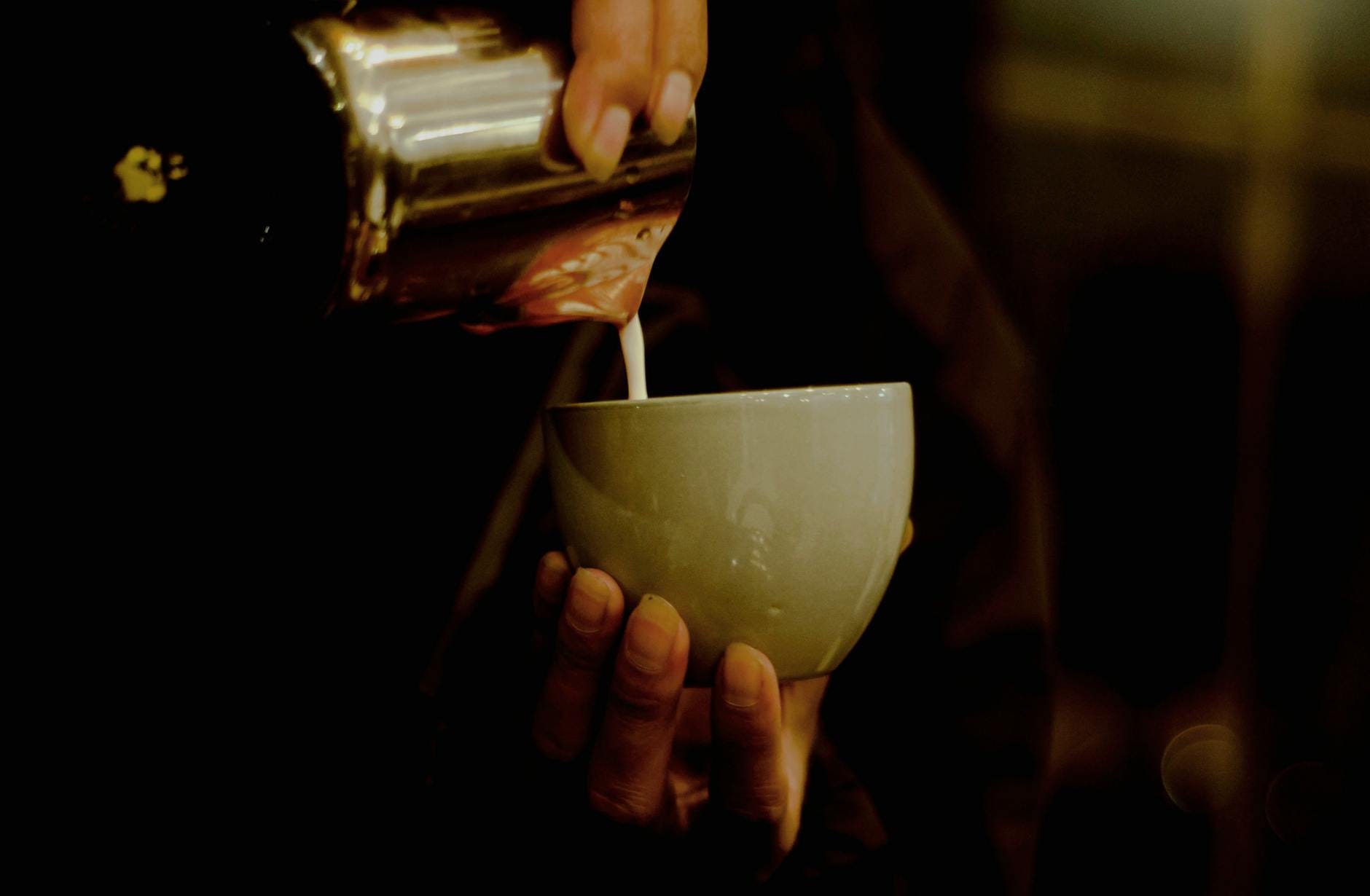 Mleko wlewane do filiżanki espresso podczas przygotowywania cappuccino