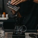 Barista przygotowujący kawę metodą przelewową w kawiarni