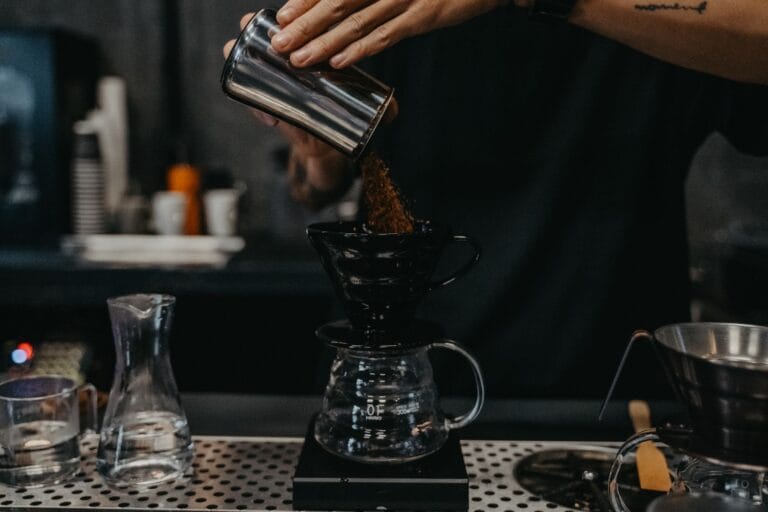 Barista przygotowujący kawę metodą przelewową w kawiarni