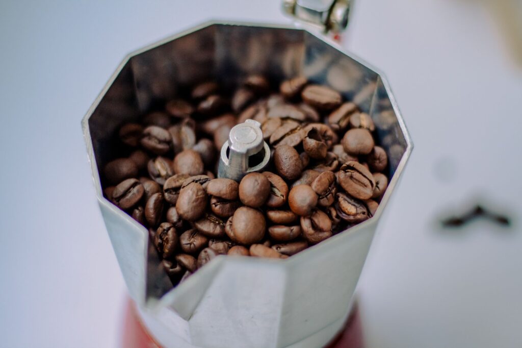 Zbliżenie ziaren kawy w metalowej kawiarce espresso